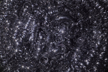 Dense field of curled metal shaves with reflective surfaces and twinkling highlights. This abstract...