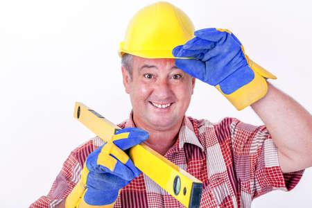 Friendly construction worker with a spirit level and safety glovesの写真素材