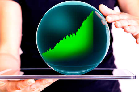 Hand holding tablet pc with glass globe and chartの写真素材