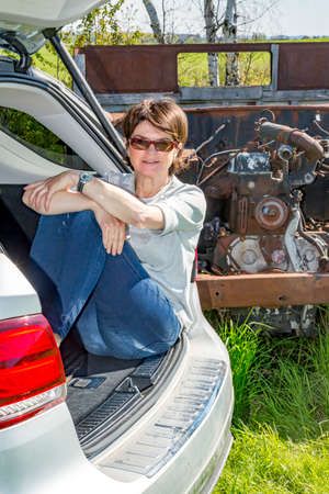 Woman sitting in trunk of carの写真素材