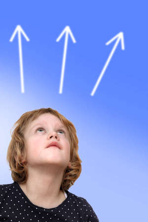 Child looks upwards on arrowsの写真素材