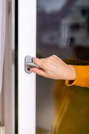 Woman opens the window to ventilate