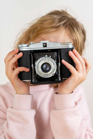 Child holds nostalgia camera in hands