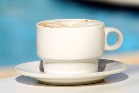 Cappuccino cup by the poolの写真素材