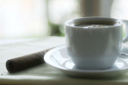 a cup of coffee with cigar on the tableの写真素材