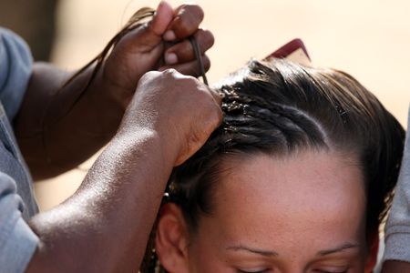 two caribbean women making braidsの写真素材