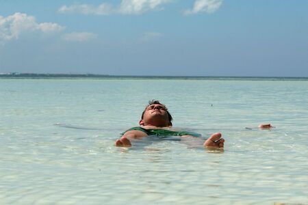 man swimming in caribbean sea enjoying the sunの写真素材