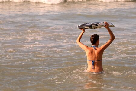 Bikini Girl with boogie board in the ocean