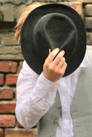 man with hat posing at the brick wallの写真素材