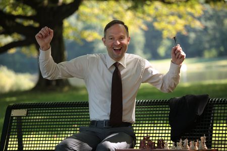 happy businessman playing chess in a city parkの写真素材