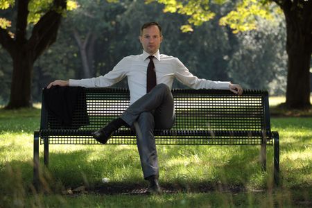 businessman sitting on the beach in a city parkの写真素材
