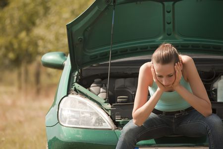 sad woman with a broken carの写真素材