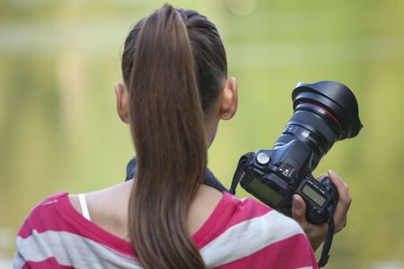 Female Photographer with professional camera in a parkの写真素材