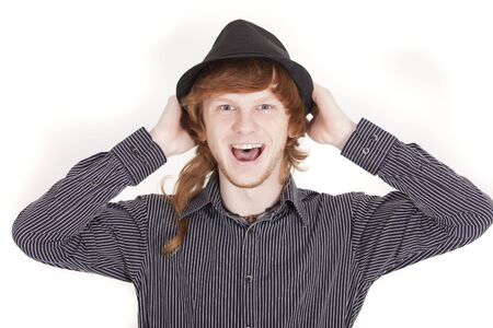 laughing man holding his hat on a white backgroundの写真素材