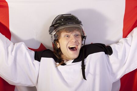 happy hockey player in helmet holding canadian flagの写真素材