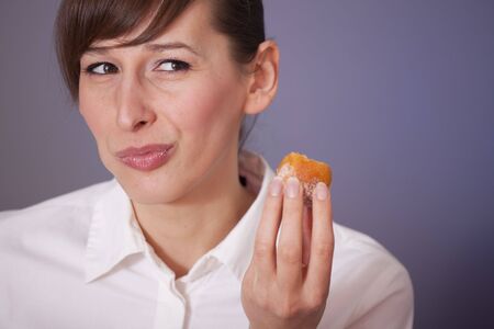 happy woman eating sugar cakeの写真素材