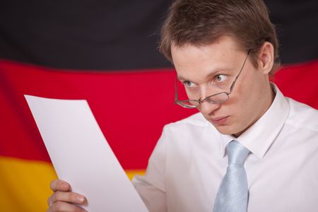 politician speaker reading notices in front of a german flagの写真素材