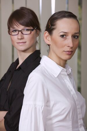 two young businesswomen standing in the officeの写真素材