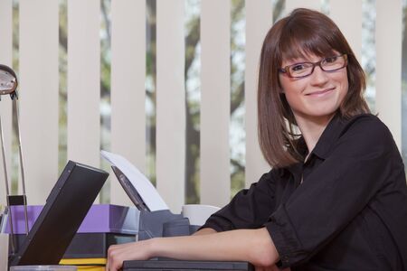 happy woman holding laptop computer in a office