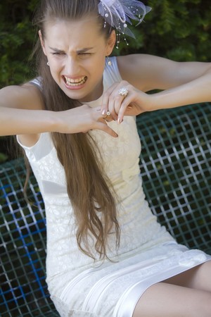 angry bride crying and pulling off a ring from her finderの写真素材