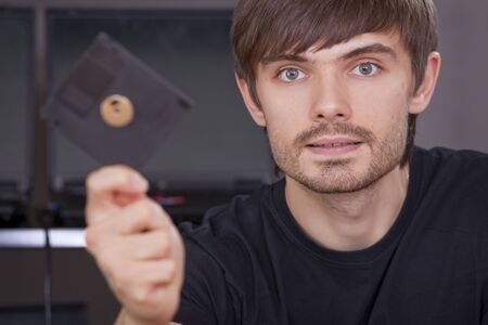 hacker holding floppy disk with data in the handの写真素材