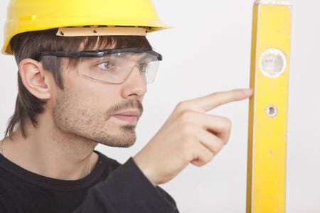 portrait of construction worker with level on white background