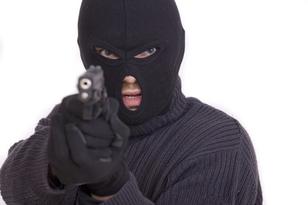 thief with gun aiming into a camera - isolated on white backgroundの写真素材