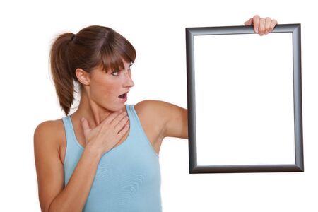 surprised woman holding empty picture frame on a white backgroundの写真素材