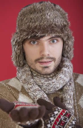 young man in winter clothes making helping hand gestureの写真素材