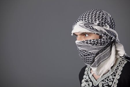 portrait of islamic man in headscarf over grey backgroundの写真素材