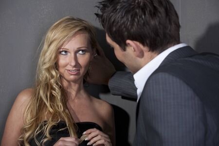 Man flirting with a woman standing at the wallの写真素材