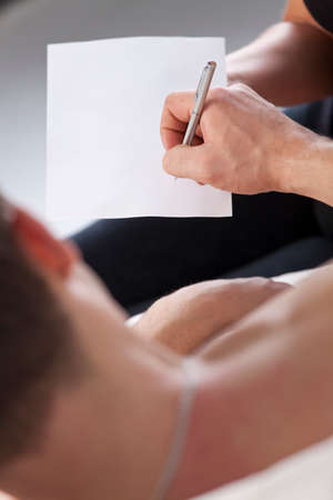 Sick man in bed signs empty paper or testamentの写真素材