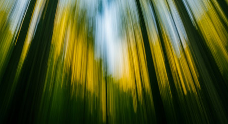 An abstract view of a forest, captured with motion blur to create a dynamic and colorful representation of natures beauty and energy.の素材