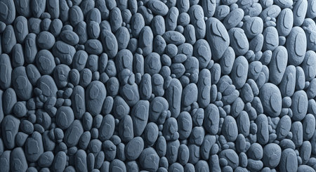 A close-up of a textured surface featuring smooth, rounded stones or pebbles, creating a natural and organic pattern with cool, muted colors.の素材