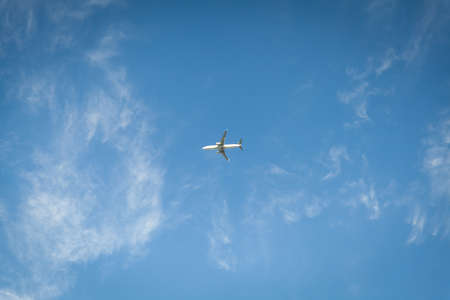 A plane flying blue sky with clouds in the background