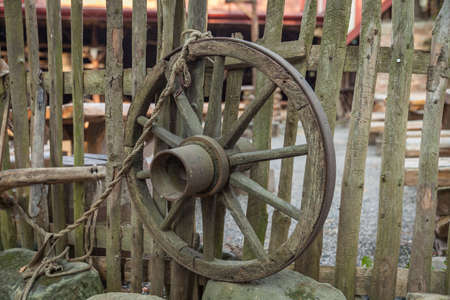 Round from an old farmer's car hanging on a wooden fence in a medieval castleの写真素材
