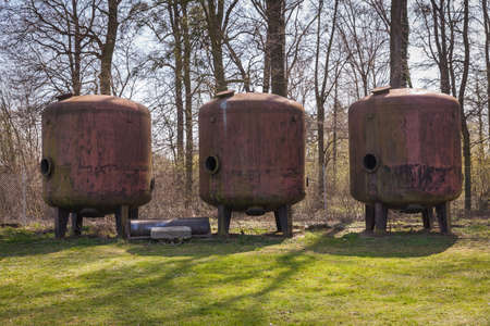 Three old rusty metal container in a secluded forestの写真素材