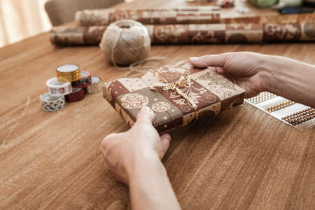 Time for gifts - gift box in hand girls on wood tableの写真素材