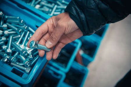 young man purchasing a hand tool in hardware shop