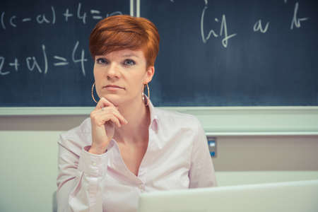 young woman prepares a teaching lesson in class on her computer