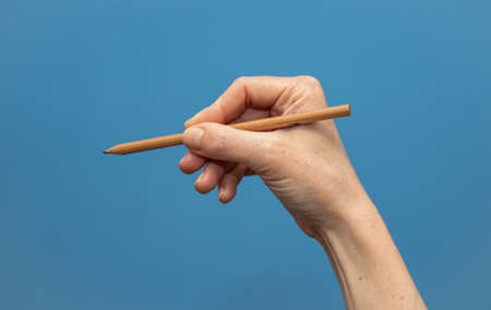 young woman showing hands on blue background. Attractive presentation of hands and nailsの写真素材