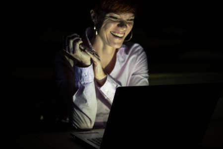 young woman works with a laptop in classrooms at the university. She studies and prepares homework as a student and teacherの写真素材