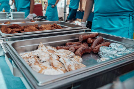 Catering for birthday party, wedding, event. Grilling meat, corn, burger, sausage, sunflower, vegetables. Fruit Dishes, Dessert, Salads, Pasta, Sweetsの写真素材