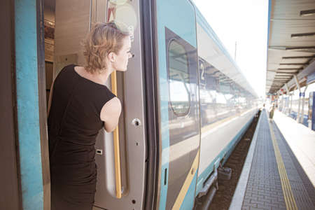 Young attractive woman bussinessman says goodbye to a boarder on train train. He enters the train...