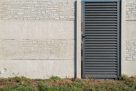 Concrete fence with a gate surrounds private property