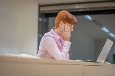 Young beautiful woman on a university lecture working on a laptopの写真素材
