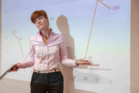 Young teacher lectures at the School of Mathematics, shows graphs on white plates