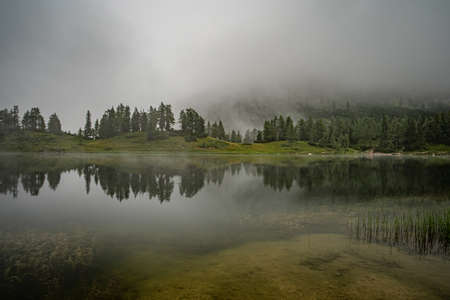 hikers in the austrian alps walk on mountain hiking trails in the woods around the lakes