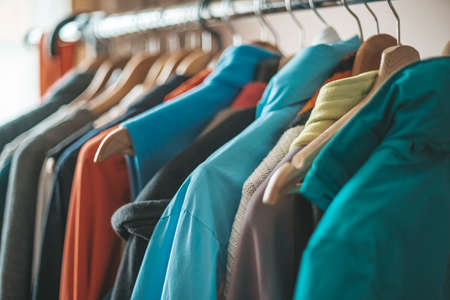 various clothes on the stand on the hangers in the wardrobe