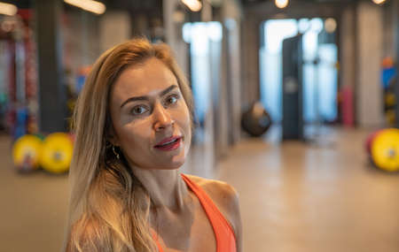 young pretty woman resting in gym after exerciseの写真素材